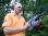 Heumann mit Lithium Ionen Bohrhammer vor Wald.